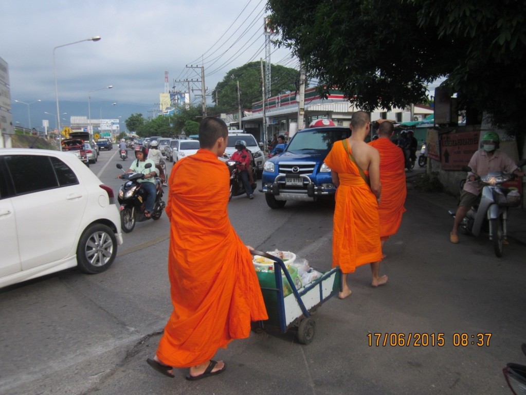 Monks bearing alms in the morning with no pavement to walk on. 